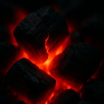 Yaxın planda parlayan qırmızı köz parçaları